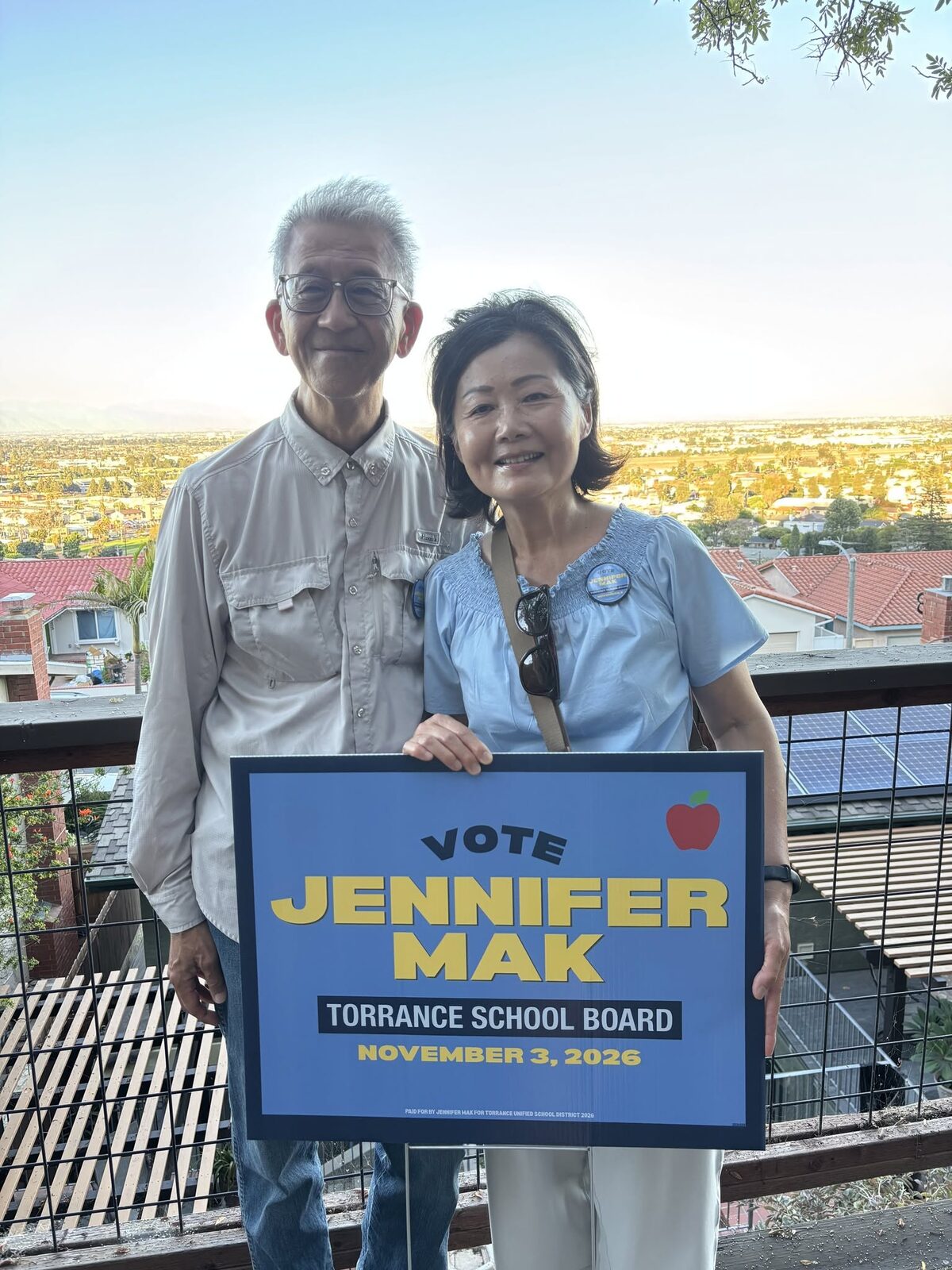 Jennifer Mak and her husband with a Vote Jennifer Mak yard sign