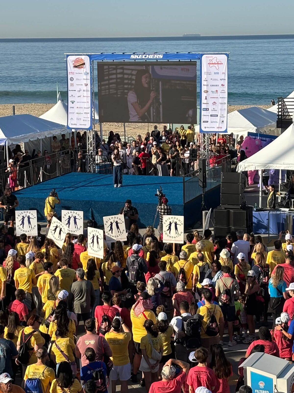 Crowds of walkers in school T-shirts in front of the Skechers stage